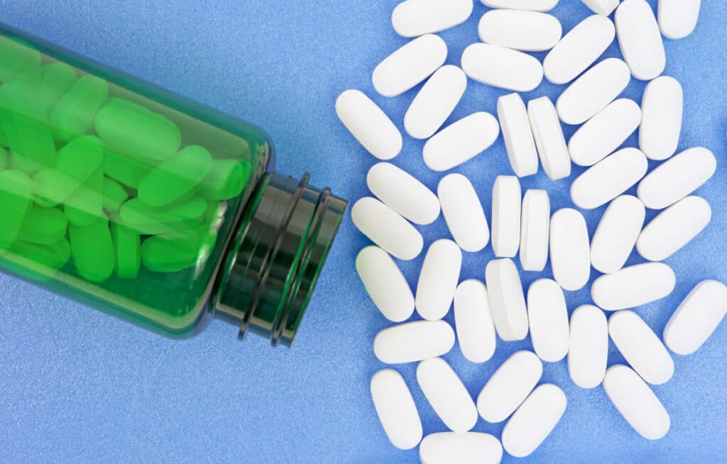 Magnesium pills spill out of green bottle