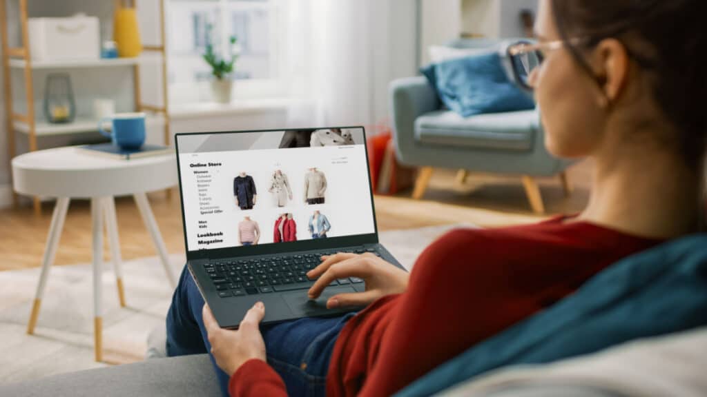 A woman sitting on her couch shopping online