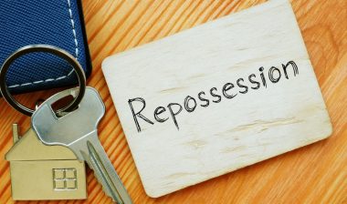 House keys next to a note that reads"repossession" representing the General Credit Acceptance settlement.