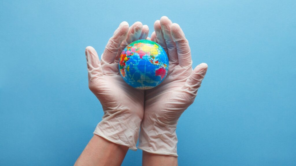 Globe in medically gloved hands.