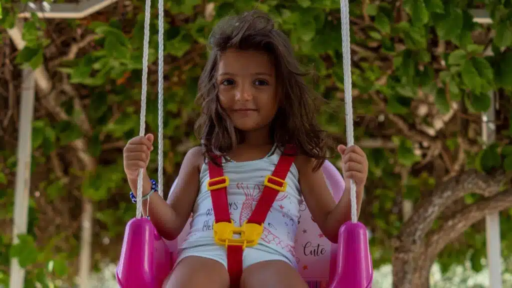 kid in outdoor swing
