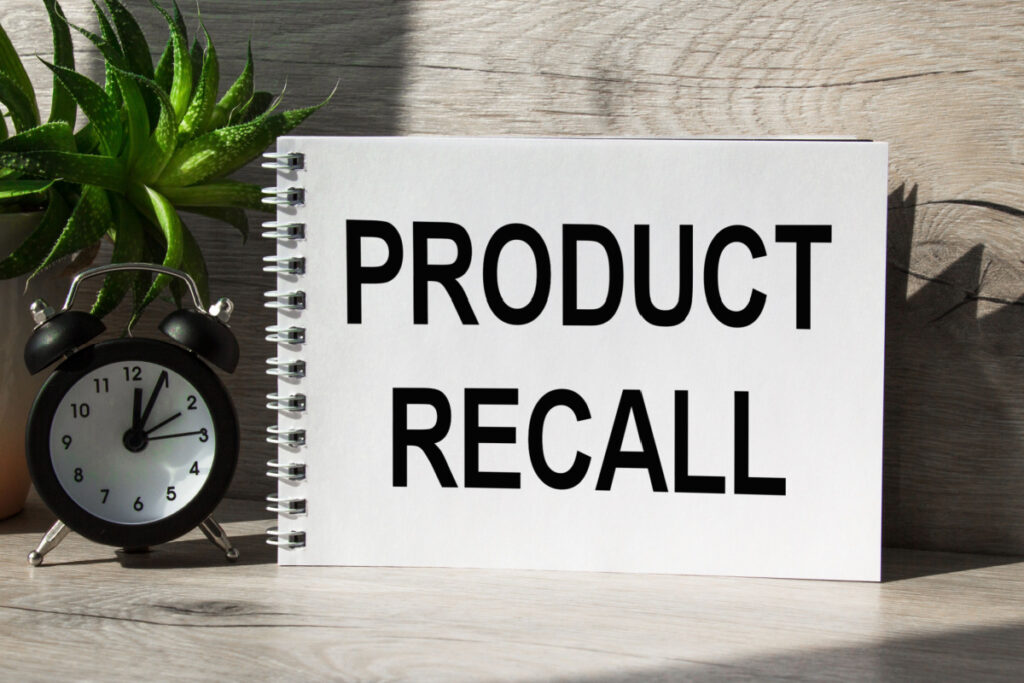 "Product Recall" written on notepad next to alarm clock