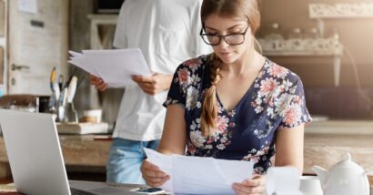 A young couple looking at foreclosure paperwork, representing the Michigan county tax foreclosure settlement.