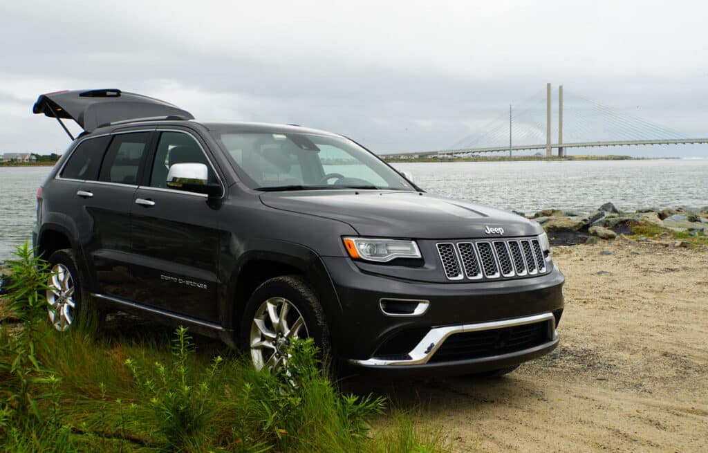 2016 black Jeep Cherokee parked on a shore.