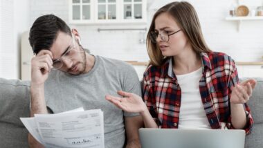 wife and husband checking details of bills trying to understand why fees are so high.