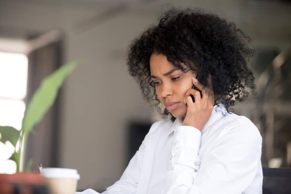 Young concerned woman talking on the phone.