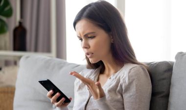 Irritated woman looking at her phone, representing the Shark Bar TCPA settlement.