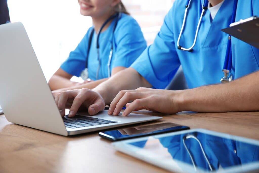 Close up of nursing students using a laptop and studying, representing the Stone Academy class action lawsuit.