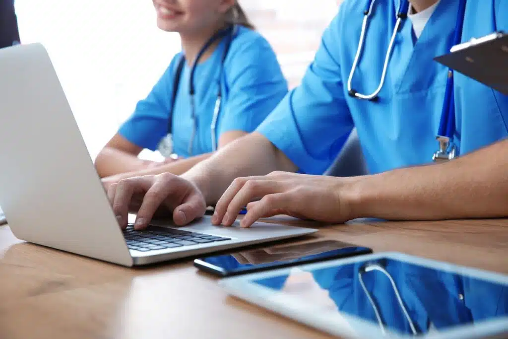 Close up of nursing students using a laptop and studying, representing the Stone Academy class action lawsuit.