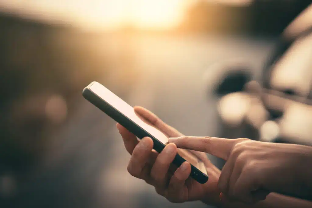 Close up of a woman's hands using a smartphone, representing the Kaiser class action.