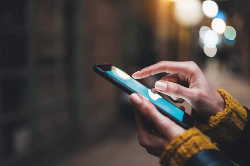 Close up of a persons hands using a smartphone, representing the Hearst apps class action.
