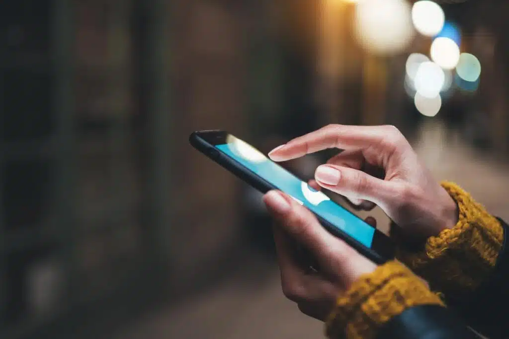 Close up of a persons hands using a smartphone, representing the Hearst apps class action.