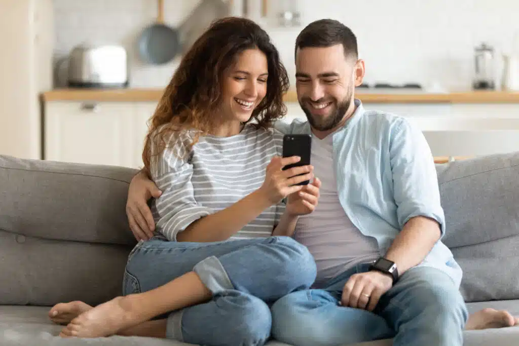 Young couple looking at a phone, representing the Premom fertility app data class action settlement.