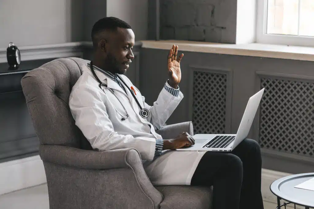 A doctor in an office on his laptop for a telehealth appointment with a patient, representing the Monument health information sharing class action.