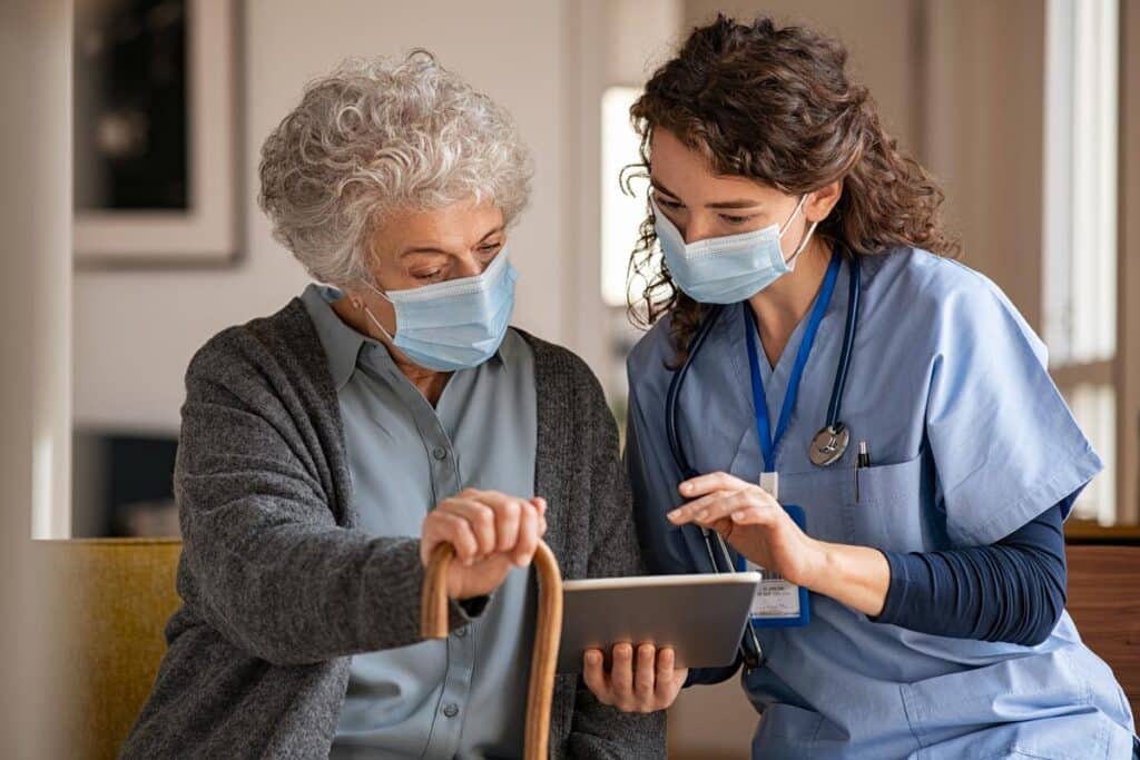 Senior lady and doctor looking at information on a tablet, representing the SuperCare Health data breach class action lawsuit settlement.