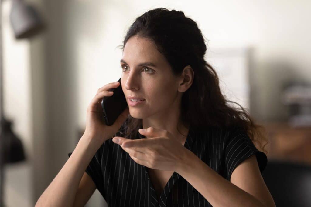 Close up of a woman talking on the phone, representing the Farfetch call recording class action settlement.