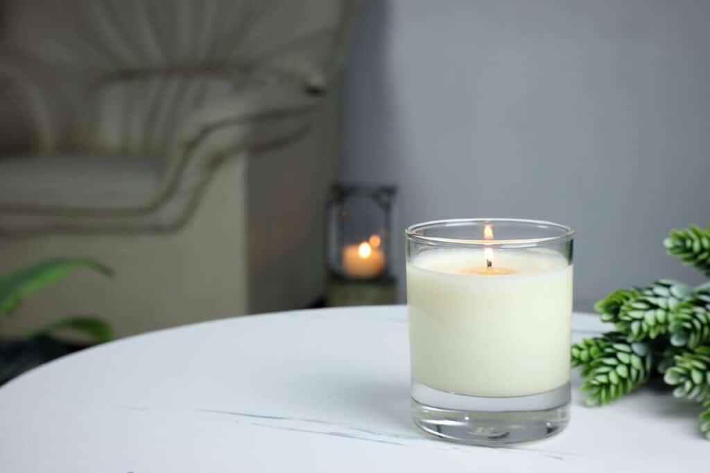 Close up of a white candle on a tabletop.