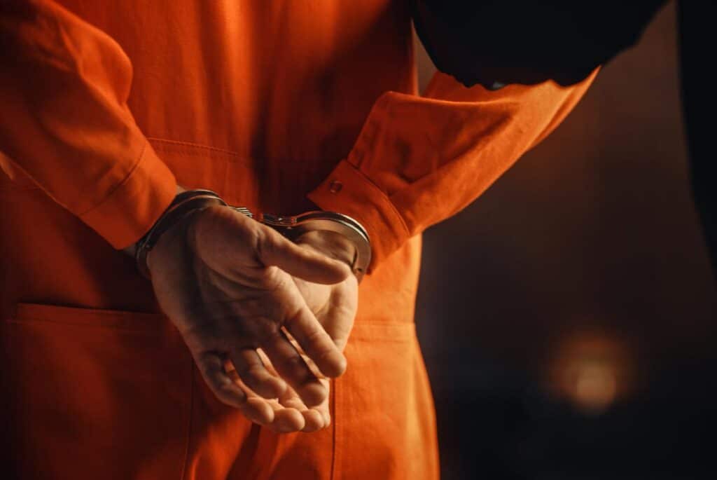 Close up of a prisoner in handcuffs, representing the Inmate Services class action settlement.
