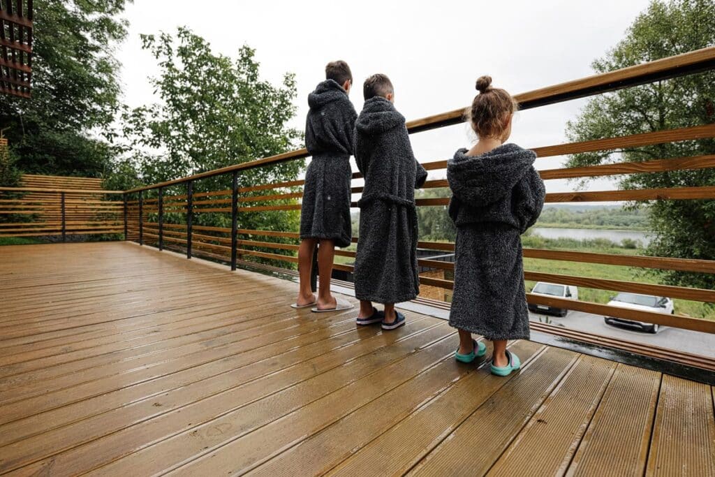 Three young kids wearing bath robes.