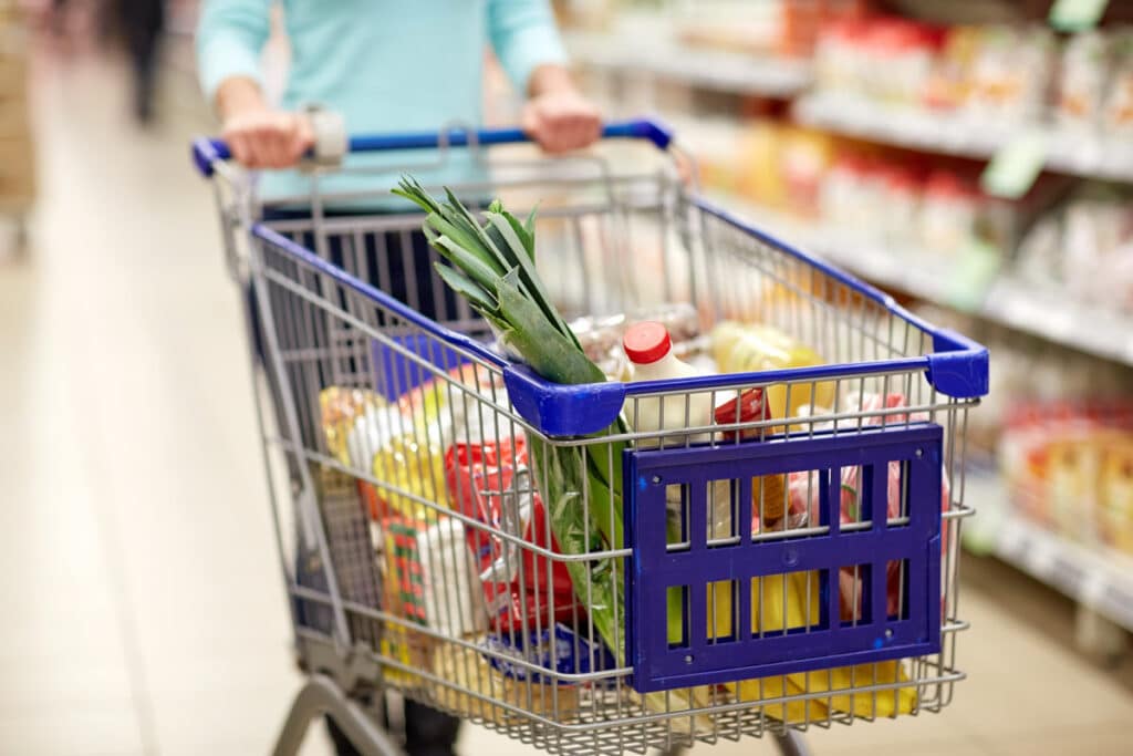 Close up of a shopping cart filled with groceries, representing Food Allergy Awareness Month.
