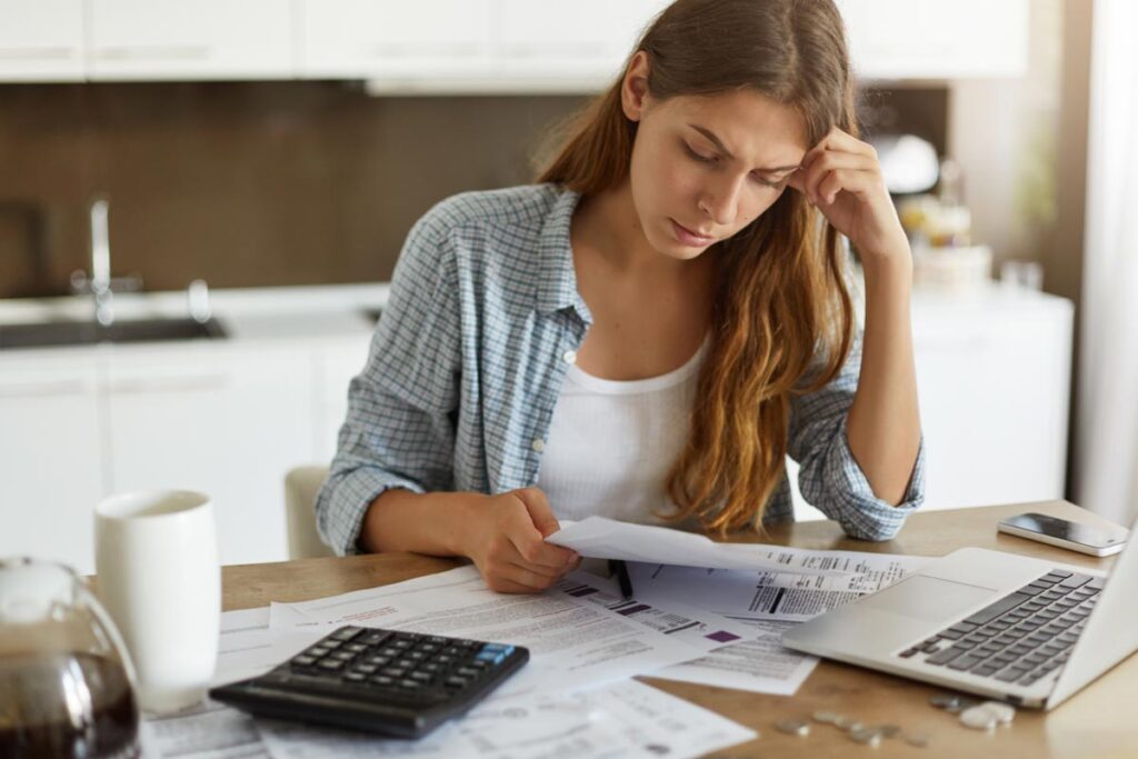 Young concerned woman looking at a bill, representing the Billings, Montana, utility fees class action lawsuit settlement.