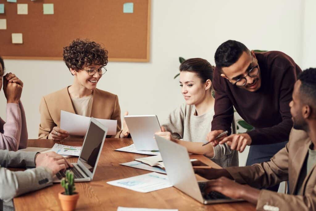 Group of coworkers working around a wooden table, representing the job satisfaction study.