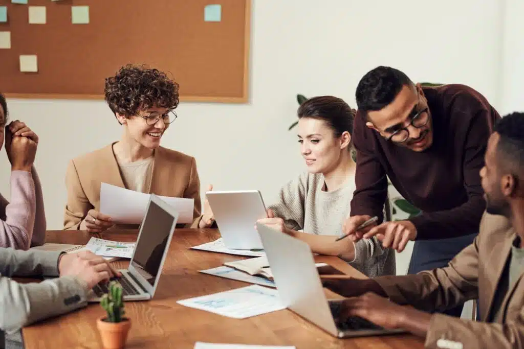 Group of coworkers working around a wooden table, representing the job satisfaction study.