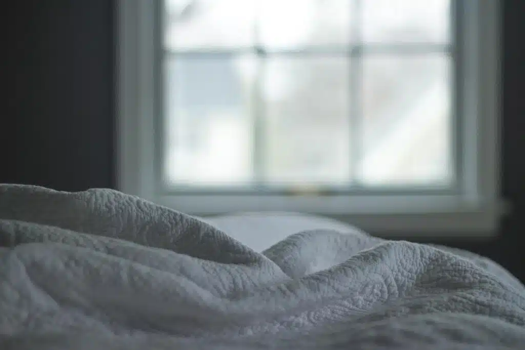 White linen bedding is seen, representing the Simmons and Beautyrest products class action.