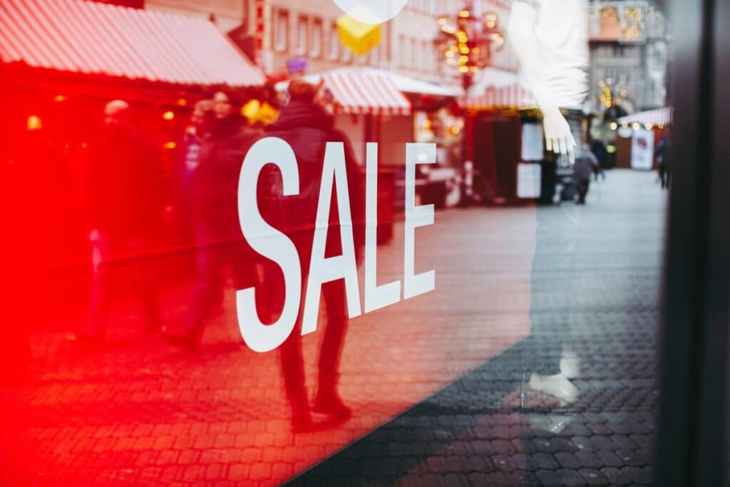 Close up of a sale signage in a window, representing false reference pricing.