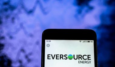 Eversource logo displayed on a smartphone screen, representing the Eversource settlement.
