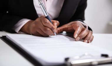 Close up of a woman's hands filling out a job application, representing the Computer Generated Solutions settlement.