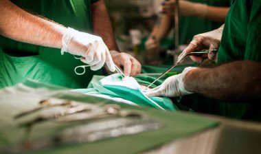 Close up of two suregons hands performing a surgery, representing the instrument sterilization class action lawsuit.
