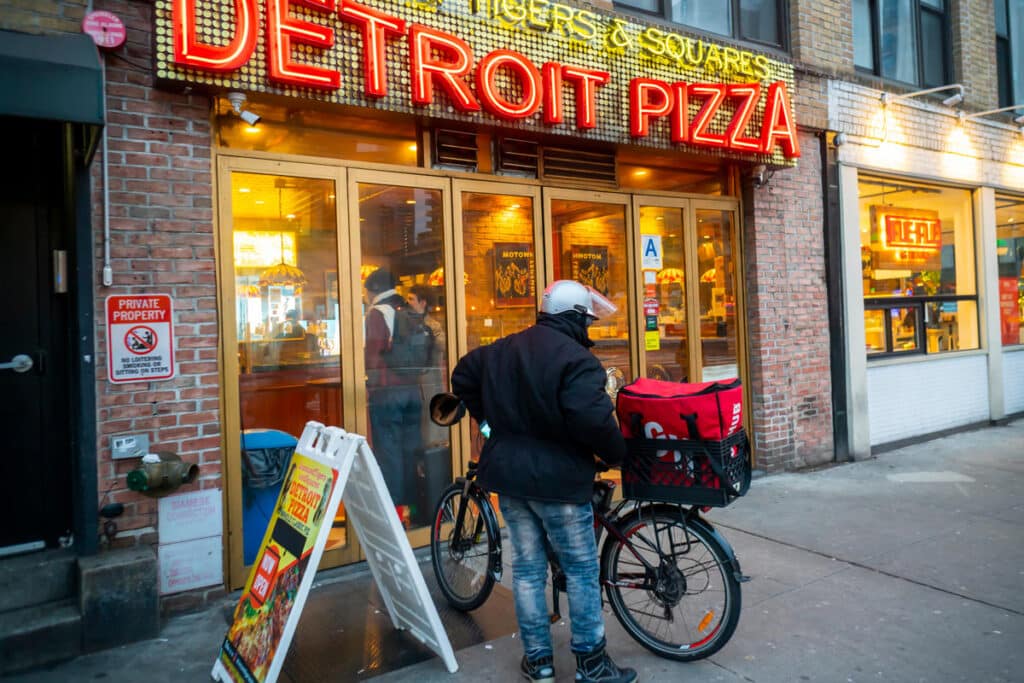 Delivery worker preparing to deliver food, representing the New York City food delivery minimum wage.
