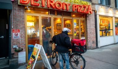 Delivery worker preparing to deliver food, representing the New York City food delivery minimum wage.