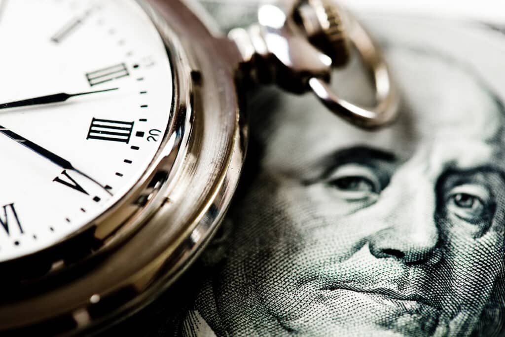 Close up of money and a clock, representing the Forest River Manufacturing overtime class action lawsuit settlement.