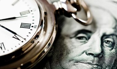 Close up of money and a clock, representing the Forest River Manufacturing overtime settlement.