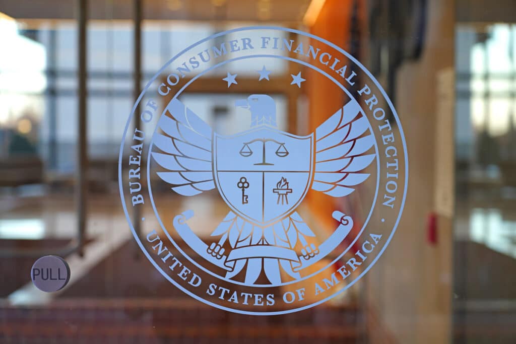 Consumer Financial Protection Bureau signage on a glass window, representing the OneMain CFPB fines.
