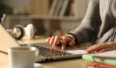 A female student using a laptop, representing the Udemy price promotion settlement.