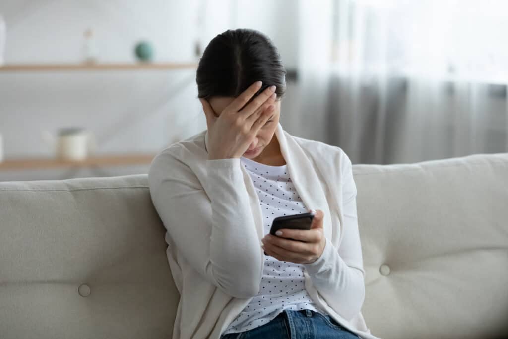 Irritated young woman looking at her phone, representing the Rocket Mortgage class action.