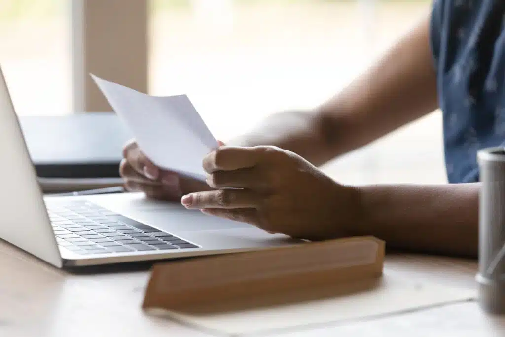 Close up of a woman reading a debt collection notice, representing the Oliveri & Associates debt-collection settlement.