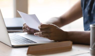Close up of a woman reading a debt collection notice, representing the Oliveri & Associates debt-collection settlement.