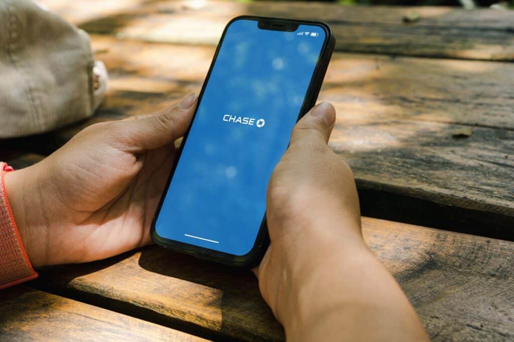 Close up of a person holding a smartphone with Chase app displayed, representing the Chase/Zelle class action.