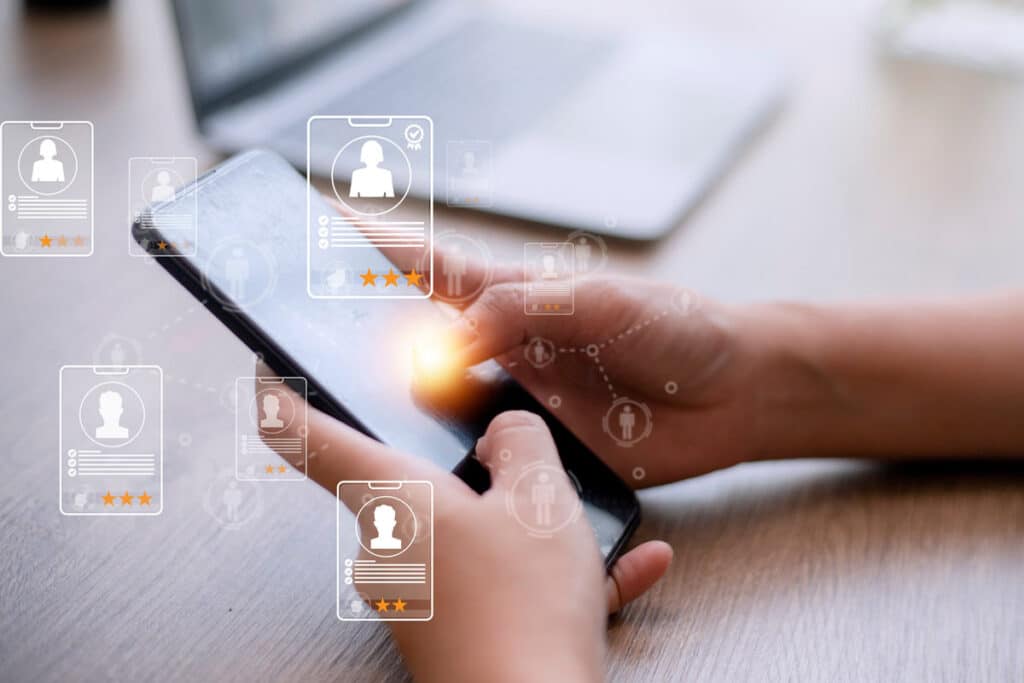 Hands using a smartphone with a recruitment overlay, representing the Tranzact settlement.