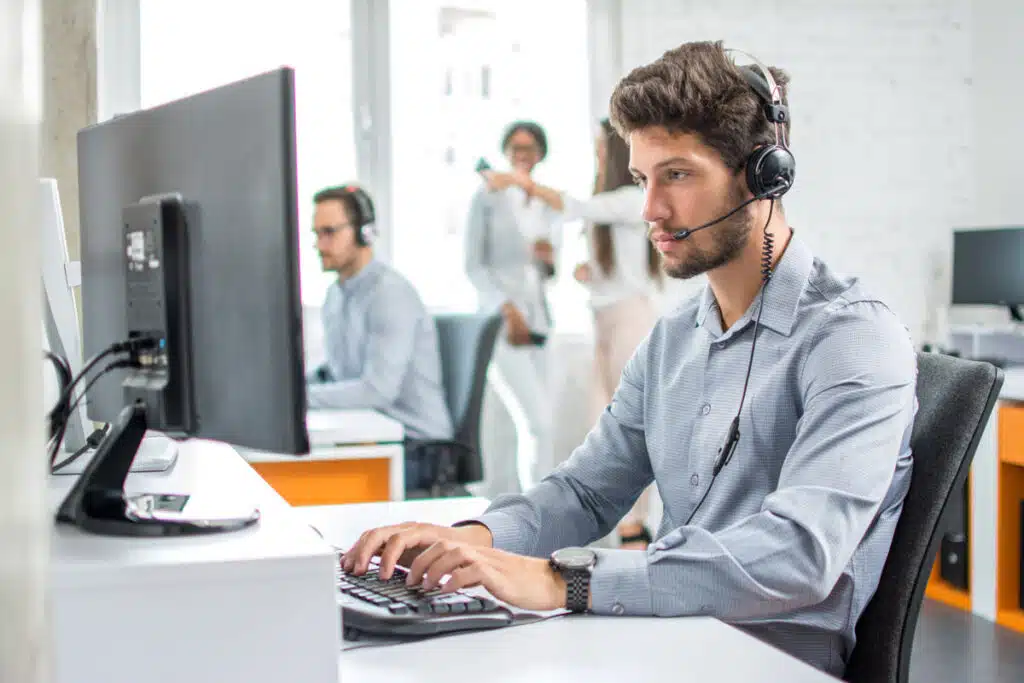 A young customer service worker typing on a computer, representing the Top Flite Financial CIPA settlement.