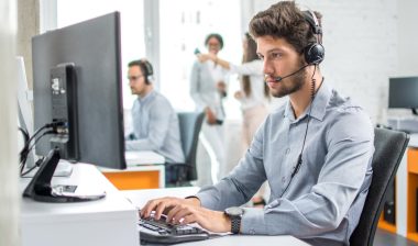 A young customer service worker typing on a computer, representing the Top Flite Financial CIPA settlement.