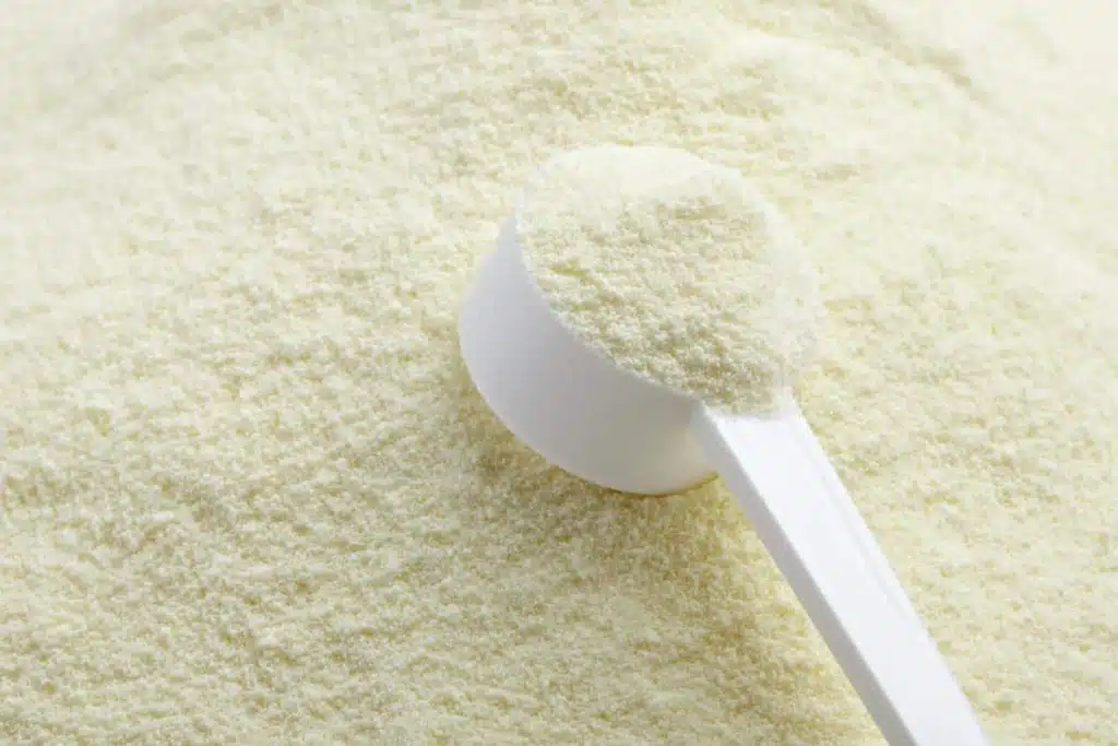 Close up of baby formula texture and spoon, representing baby formula tariffs.