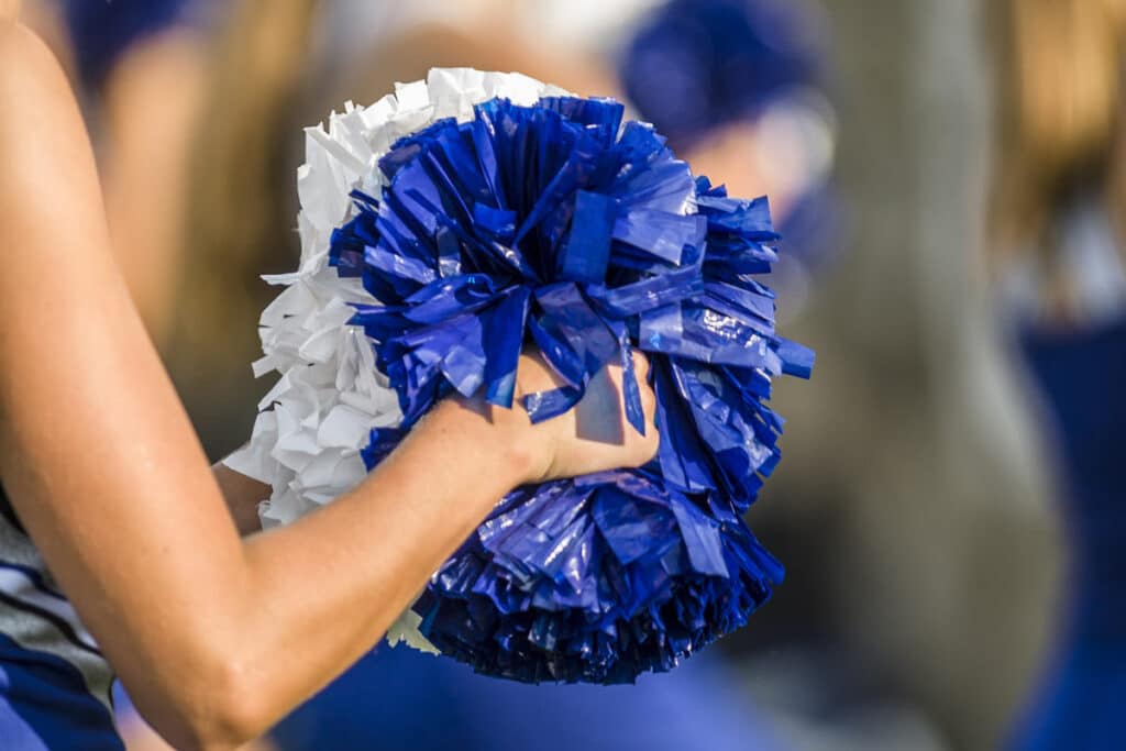 Close up of a blue and white cheerleading pom pom, representing the Varsity Brands All Star Cheer settlement.