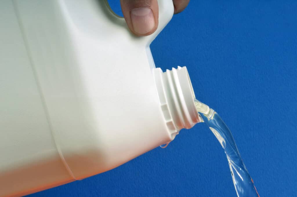 Close up of bleach being poured, representing the fake COVID cure.