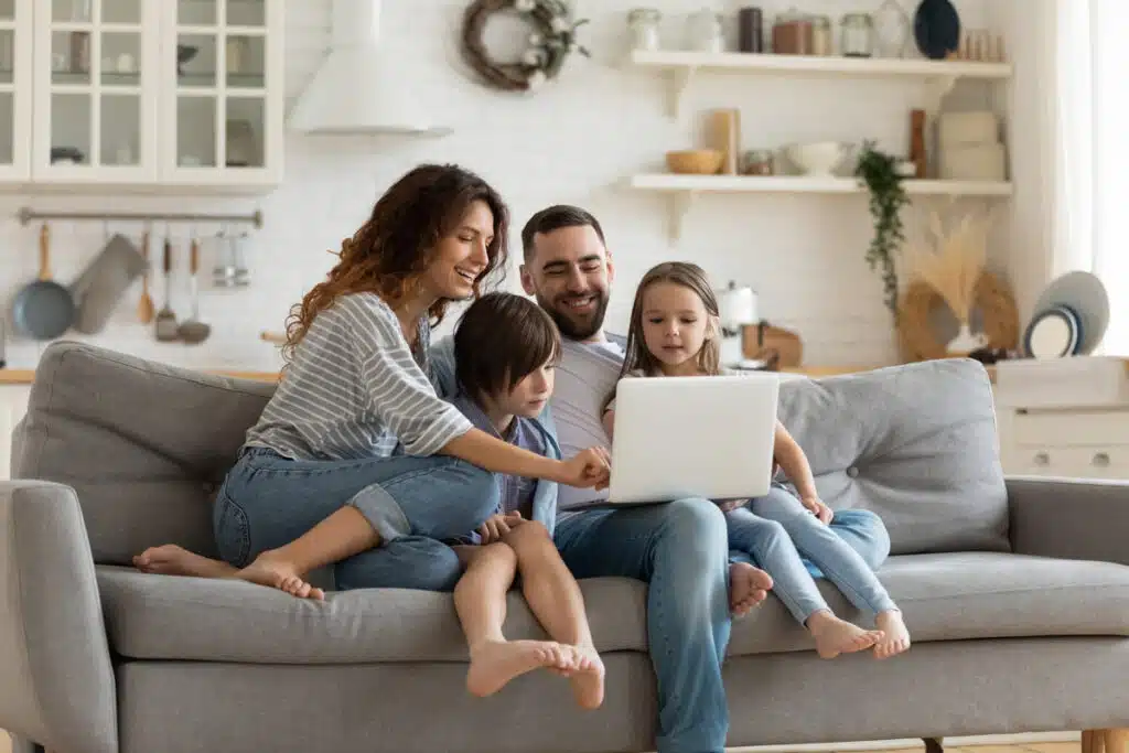 Happy family using a laptop together, representing the Oregon privacy law.