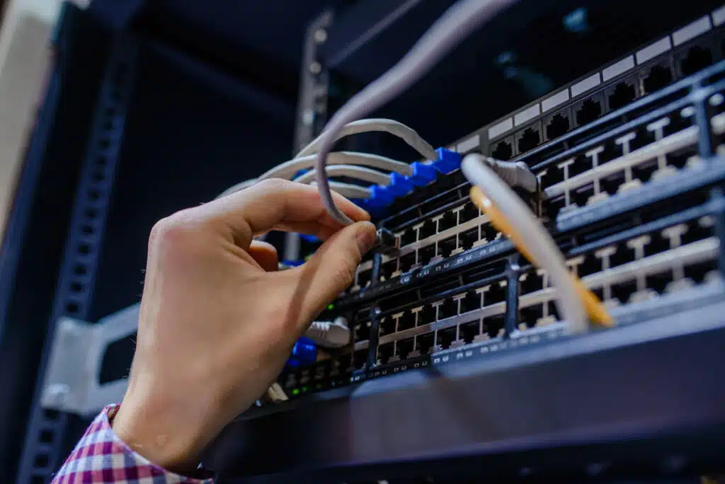 Close up of a technician adjusting network cables, representing the Citywide Home Loans data breach settlement.